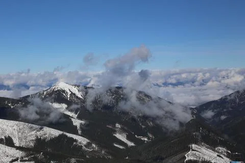 Cloud-wrapped mountain peak above ski resort valley Fotos Stock
