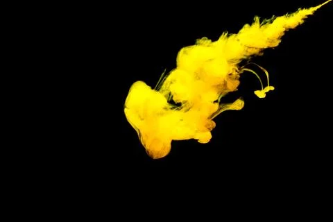 A cloud of yellow paint released into clear water. Isolate on a black backgro Stock Photos