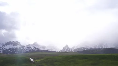 Cloudcovered mountains with grassy plains in the foreground Stock Footage 286394167
