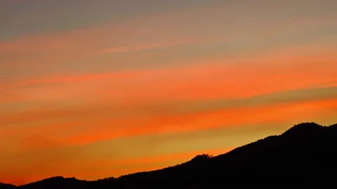 Clouded orange sky with mountain silhouette Vídeo Stock 151238565