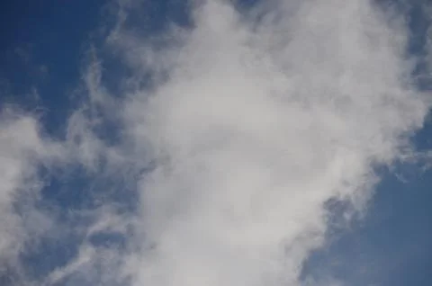 A cloudless blue sky with a few clouds scattered throughout. Stock Photos