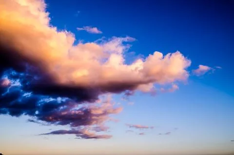 A cloudless blue sky with a large cloud in the middle Stock Photos