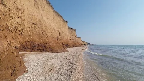 Cloudless morning on the beach with large cliffs, the camera moves smoothly Stock Footage 124166132