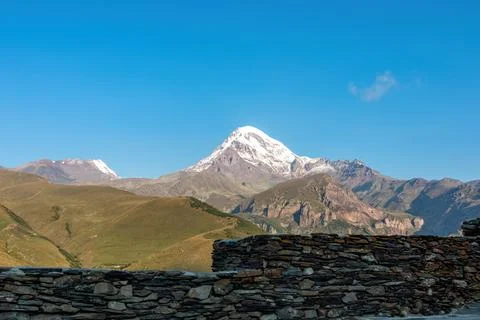 A cloudless view on Mount Kazbeg in Caucasus, Georgia. There slopes are bar.. Stock Photos