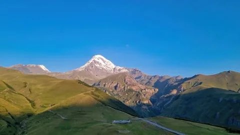 A cloudless view on Mount Kazbeg in Caucasus, Georgia. There slopes are bar.. Stock Photos