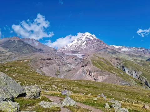 A cloudless view on Mount Kazbeg in Caucasus, Georgia. There are lush pastu.. Stock Photos