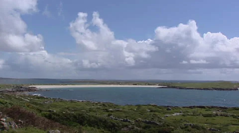 Clouds above Atlantic ocean + pan rugged coast with showers Stock Footage 23007549