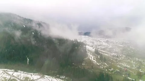 Clouds above green mountain fields with snow and grass Stock Footage 282532836