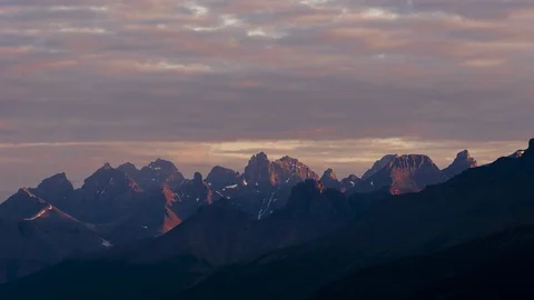 Clouds above mountains at sunrise 4K Stock Footage 107880573