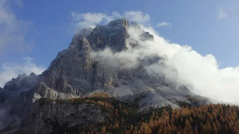 Clouds above the Pelmo mountain and a forest of orange larches, Dolomites Stock Footage 129809980
