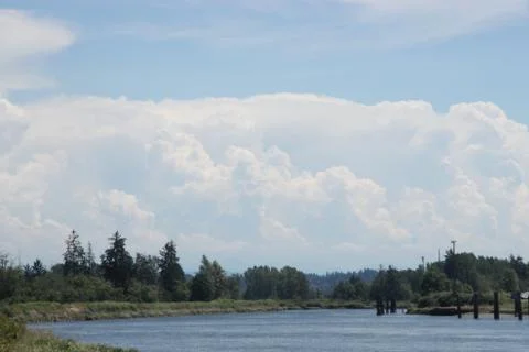 Clouds above trees and river Foto stock