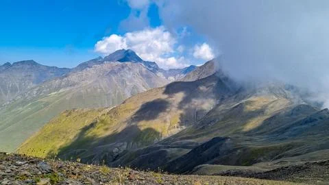 Clouds accumulating around the sharp mountain peaks of the Chaukhi Pass in .. Stock Photos
