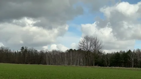 Clouds advancing over rural field and forest in timelapse Stock Footage 343070522
