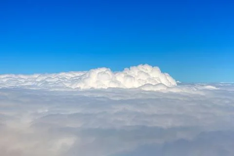 Clouds against blue sky view through an airplane window for a background. Stock Photos