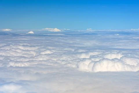 Clouds against blue sky view through an airplane window for a background. Stock Photos