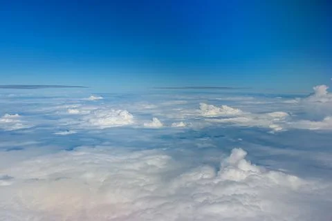 Clouds against blue sky view through an airplane window for a background. Stock Photos
