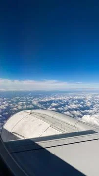 Clouds and blue sky over cabin wing during flight from one city to another .. Stock Photos