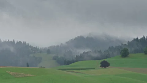 Clouds and fog rolling through hills in Switzerland Video stock 258418507