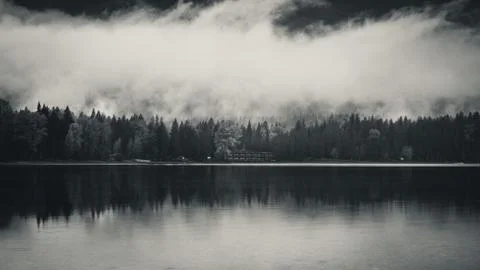 Clouds and forest reflected in a lake. Stock Photos