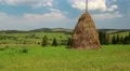 Clouds and haystack on green field HD Footage