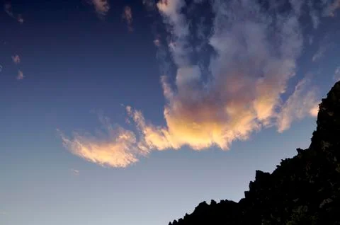 Clouds and hill at sunset Stock Photos