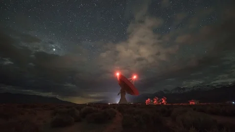 Clouds and Milky Way Galaxy drift over a large Radio Dish Stock Footage 110718178