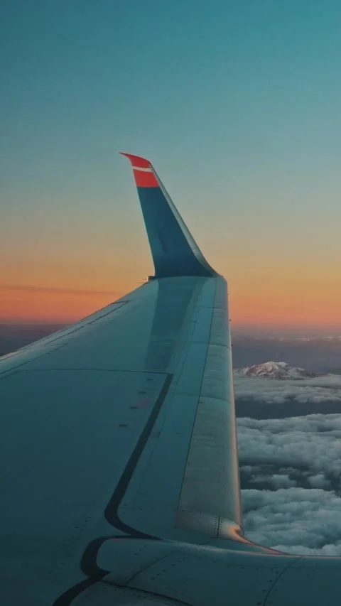 Clouds and mountains at an orange dawn behind the glass of a porthole Stock Footage 328079536