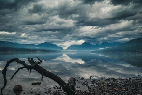 Clouds and mountains reflected in a calm lake. Stock Photos