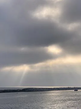 Clouds and rays of sun over the sea Stock Photos