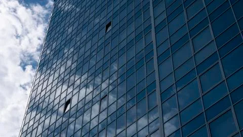Clouds and reflection of clouds in a skyscraper. Building with mirrored walls Stock Photos