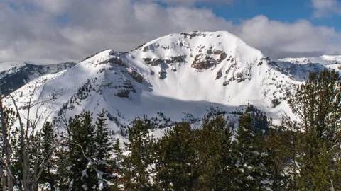 Clouds and shadows moving across big mountain face in winter Stock Footage 167049086