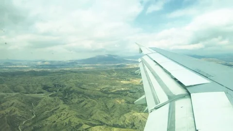 Clouds and sky and mountains as seen through window of an aircraft Stock Footage 81500249
