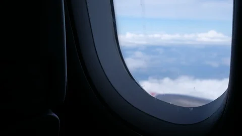 Clouds and sky as seen through a window of an aircraft flying Stock Footage 99104131