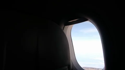 Clouds and sky as seen through window of an aircraft flying Stock Footage 103196157