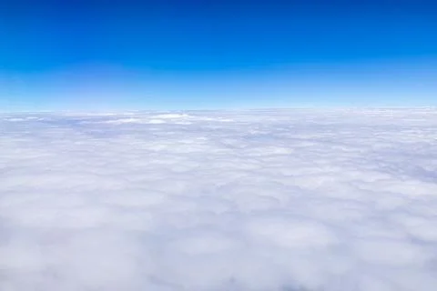 Clouds and sky as seen through window of an aircraft. Stock Photos