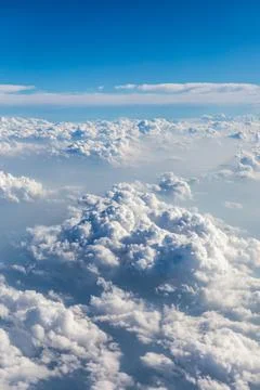 Clouds and sky as seen through window of an aircraft. Stock Photos