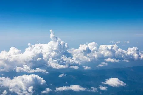 Clouds and sky as seen through window of an aircraft. Stock Photos