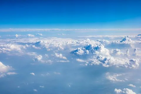 Clouds and sky as seen through window of an aircraft. Stock Photos