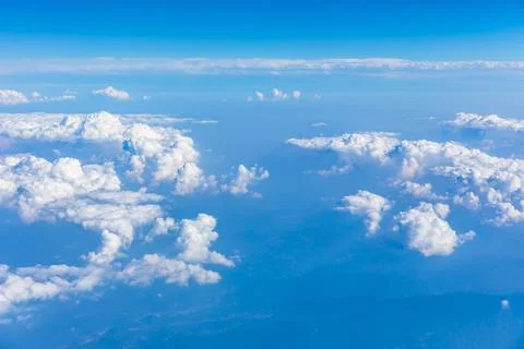 Clouds and sky as seen through window of an aircraft. Stock Photos