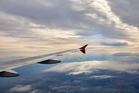 Clouds and sky as seen through window of an aircraft at sunset Stock Photos