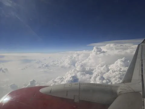 Clouds and sky as seen through window of an aircraft. Stock Photos