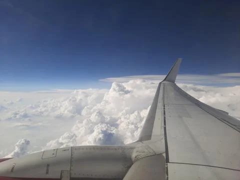 Clouds and sky as seen through window of an aircraft. Stock Photos