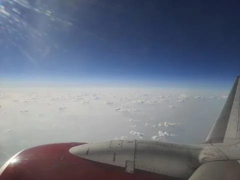 Clouds and sky as seen through window of an aircraft. Stock Photos