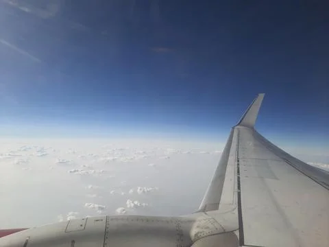 Clouds and sky as seen through window of an aircraft. Stock Photos