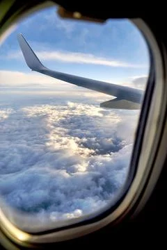 Clouds and sky as seen through window of an airplane during flight Stock Photos