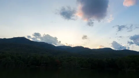 Clouds and sunbeam over mountain and birds flying back to the nest. Stock Footage 157150558