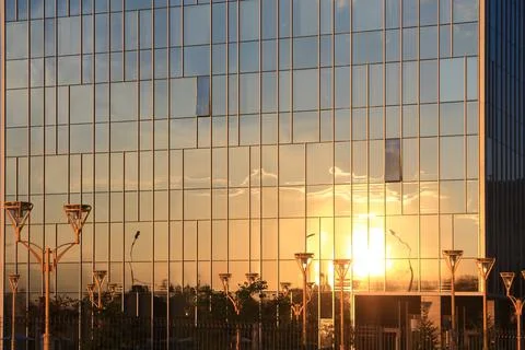 Clouds and sunset reflection in glass office building. Stock Photos
