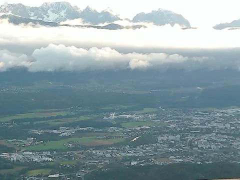 Clouds approaching the valley, mountains and a small forest are visible Foto stock