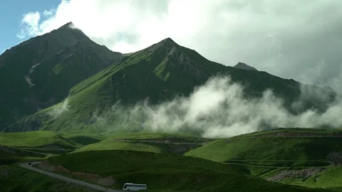 Clouds are approaching the sky road with moving cars between the green tops. Stock Footage 115963739