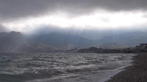 Clouds are cut by the rays of the sun over the raging sea Stock Footage 88440078